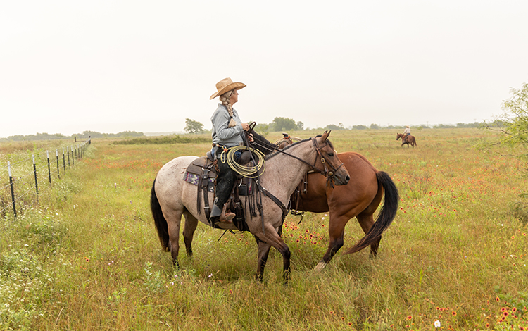 Women on horse back in field 